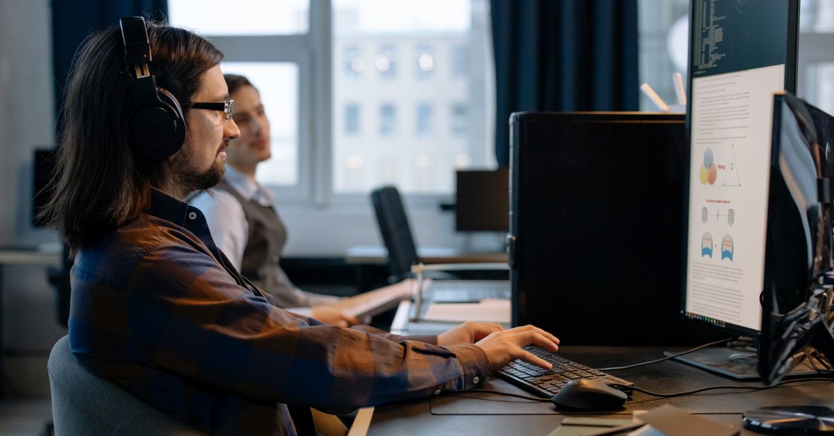 Two programmers working together with focus on coding in a modern, tech-savvy office environment.